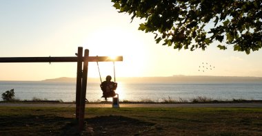 A girl swings on a swing at sunset at a park, Beylikdüzü, Istanbul, Türkiye, July 24, 2020. (Getty Images Photo)