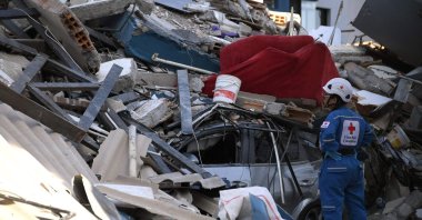 A Colombian Red Cross member looks for survivors amid the rubble of a collapsed building after an earthquake, Pereira, Colombia, Aug. 10, 2026. (AFP Photo)