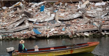 A person rides a boat beside a collapsed building, La Guaira, Venezuela, Aug. 9, 2026. (EPA Photo)