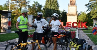 Federico Demasi (C) and Baasansuren Gankhurel (R) talk with Hakan Yavuz, a local representative of a cycling association, Bilecik, northwestern Türkiye, Aug. 11, 2026. (AA Photo)