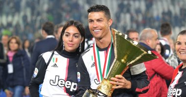 Cristiano Ronaldo #7 of Juventus FC and Georgina Rodriguez celebrate with the trophy after winning the Serie A Championship at the end of the serie A match between Juventus FC and Atalanta BC at Allianz Stadium, May 19, 2019 in Turin, Italy. (AFP File Photo)