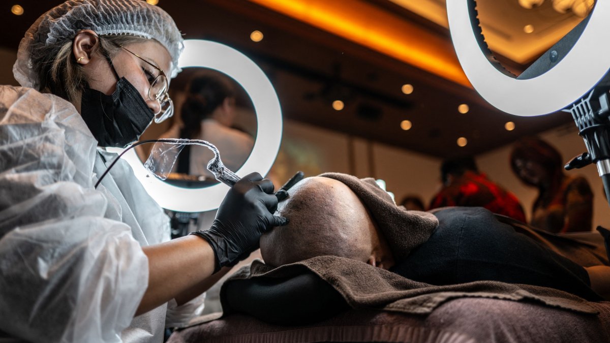 A scalp tattoo artist demonstrates a technique during a tattoo and permanent makeup contest, Naha, Okinawa, Japan, July 8, 2026. (AFP Photo)