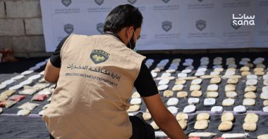 A member of Syria's Drug Enforcement Department inspects seized narcotics during an operation in Syria, in this photo released on Aug. 12, 2026. (SANA Photo)