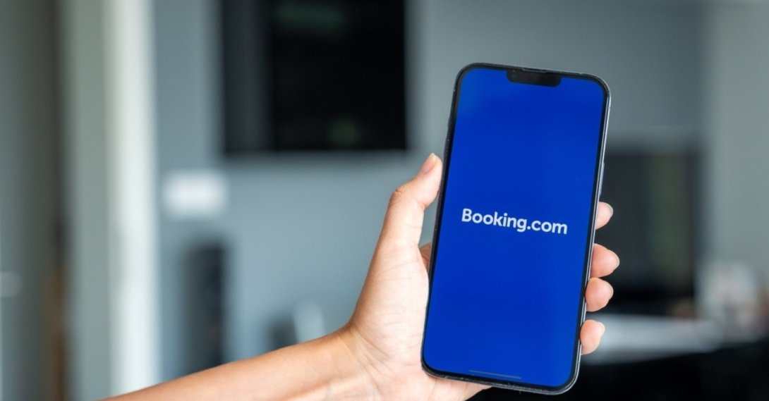 A person holding a phone with the Booking.com application on the screen, Prague, Czechia, May 2, 2024. (Shutterstock Photo)