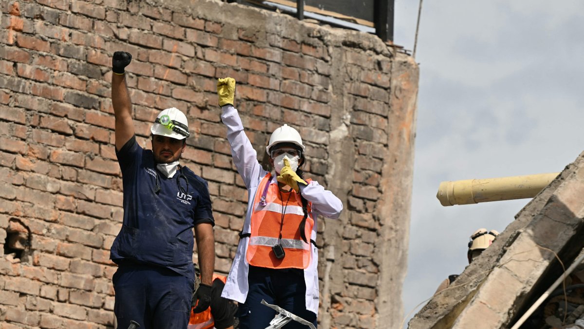 Rescuers call for silence as they search for survivors amid the rubble of a collapsed building after an earthquake in Pereira, Colombia, Aug. 12, 2026. (AFP Photo)