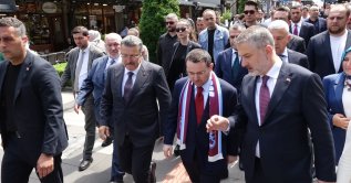 Justice Minister Akın Gürlek wearing a Trabzonspor football club scarf, a symbol of Trabzon, speaks with officials and locals during his visit to Trabzon, northeastern Türkiye, Aug. 13, 2026. (DHA Photo)