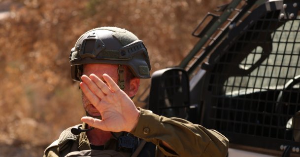 An Israeli soldier blocks a road as illegal Israeli settlers besiege a Palestinian home for the fourth consecutive day in the town of Qusra, south of Nablus, Aug.13, 2026. (EPA Photo)
