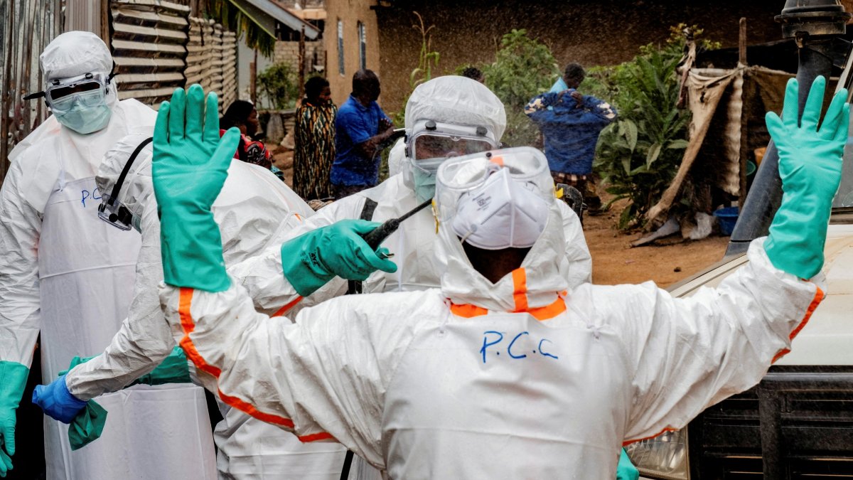 Members of the Civil Protection team, which works to help mitigate the spread of the Ebola virus, wearing personal protective equipment (PPE), disinfect after handling the body of an unidentified man who, according to his family, died of Ebola, Bunia, Ituri province, DRC, July 10, 2026. (Reuters Photo)