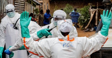 Members of the Civil Protection team, which works to help mitigate the spread of the Ebola virus, wearing personal protective equipment (PPE), disinfect after handling the body of an unidentified man who, according to his family, died of Ebola, Bunia, Ituri province, DRC, July 10, 2026. (Reuters Photo)