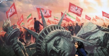 An Iranian woman walks next to an anti-U.S. billboard at Enghelab Square, Tehran, Iran, Aug. 13, 2026. (EPA Photo)