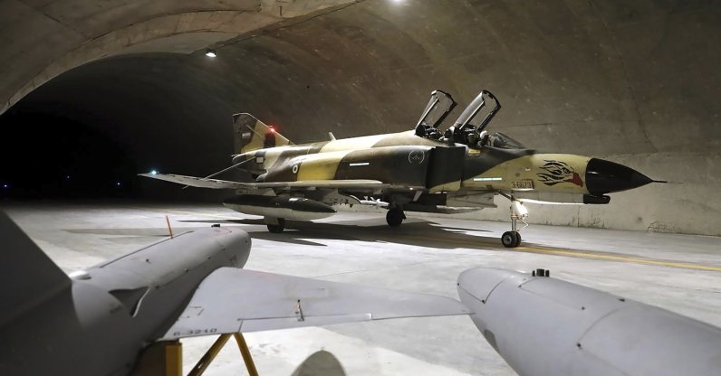 In this picture, released Feb. 7, 2023, by the official website of the Iranian Army, a fighter jet taxis as two drones are seen in the foreground at the Oghab-44, or Eagle-44, underground airbase in an undisclosed location in Iran. (AP Photo)