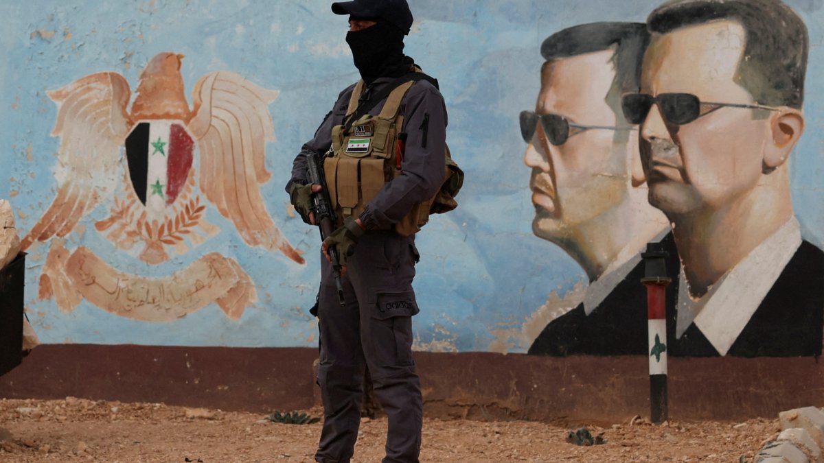 A security guard stands near an image of Syria's Bashar Assad at the fourth division headquarters, Damascus, Syria, Jan. 23, 2025 (Reuters Photo)