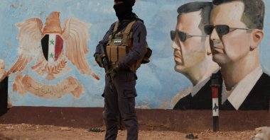 A security guard stands near an image of Syria's Bashar Assad at the fourth division headquarters, Damascus, Syria, Jan. 23, 2025 (Reuters Photo)