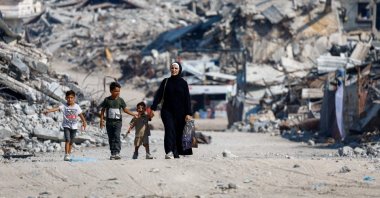 Palestinians walk past the rubble of residential buildings destroyed by Israeli attacks in Gaza City, Palestine, Aug. 15, 2026. (Reuters Photo)