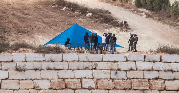Israeli soldiers are seen as Israeli settlers set up a tent just outside the entrance of a besieged Palestinian family home in the village of Qusra, south of the city of Nablus, in the Israeli-occupied West Bank, Palestine, Aug. 14, 2026. (AFP Photo)
