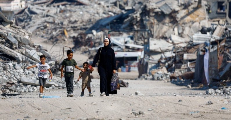 Palestinians walk past the rubble of residential buildings destroyed by Israeli attacks in Gaza City, Palestine, Aug. 15, 2026. (Reuters Photo)