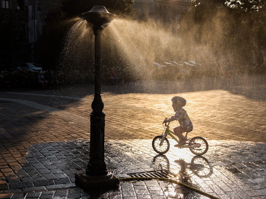 A child rides a bicycle by a water sprinkler at Podgorski Square amid a heat wave that pushed temperatures to 40 degrees Celsius, Krakow, Poland, Aug. 3, 2026. (Getty Images Photo)