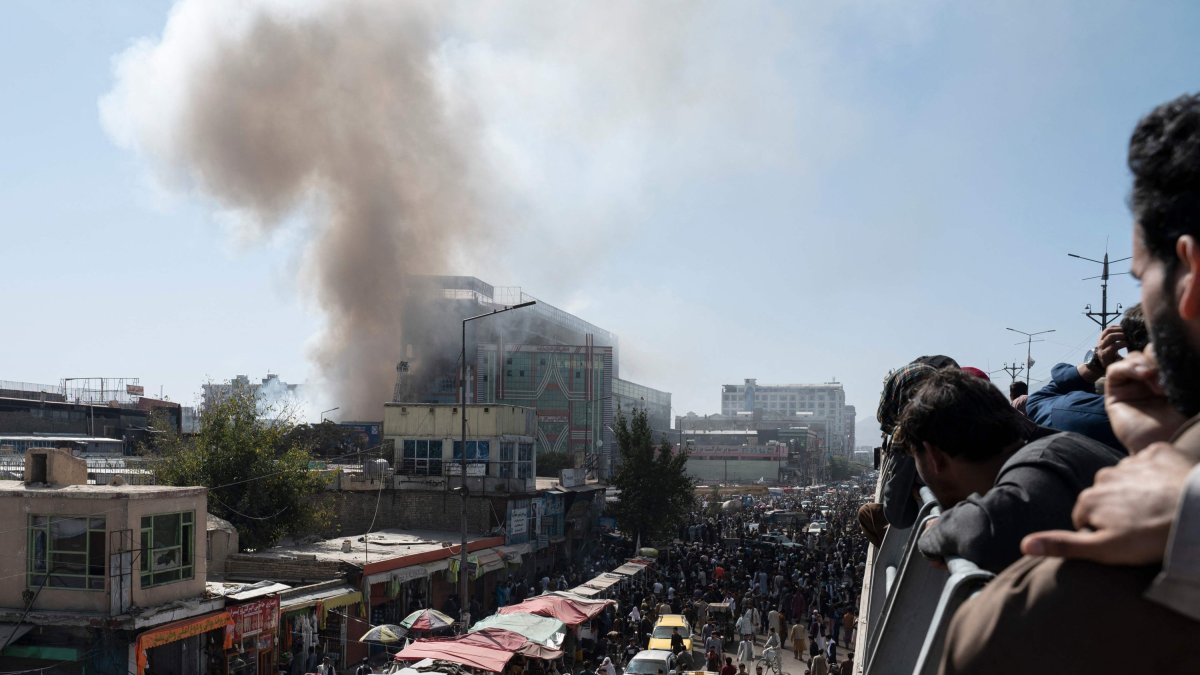 People watch smoke billowing from a fire at a business center mall in Kabul, Afghanistan, Oct. 5, 2022. (AFP File Photo)