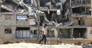 An internally displaced Palestinian man walks past the rubble of buildings destroyed by the Israeli military, in Khan Younis in the southern Gaza Strip, Palestine, Aug. 11, 2026. (AFP Photo)