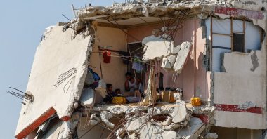 Palestinians sit inside a house destroyed by Israeli attacks, Gaza City, Palestine, Aug. 15, 2026. (Reuters Photo)