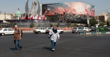 People walk past an anti-U.S. billboard at Enghelab Square, central Tehran, Iran, Aug. 9, 2026. (EPA Photo)