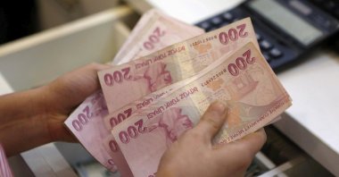 A money exchanger counts Turkish lira bills at a currency exchange office, central Istanbul, Türkiye, Aug. 21, 2015. (Reuters Photo)