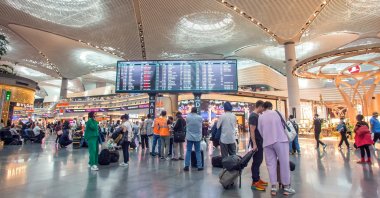 Passengers are seen near the flight timetable at Istanbul Airport, Istanbul, Türkiye, June 7, 2026. (Shutterstock Photo)
