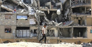 An internally displaced Palestinian man walks past the rubble of buildings destroyed by the Israeli military, in Khan Younis in the southern Gaza Strip, Palestine, Aug. 11, 2026. (AFP Photo)