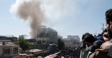 People watch smoke billowing from a fire at a business center mall in Kabul, Afghanistan, Oct. 5, 2022. (AFP File Photo)