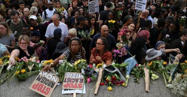 People lay flowers down at the end of a vigil by Stand Up To Racism to remember former Cambridge professor Jason Arday, who died aged 41 on Friday after resigning amid plagiarism allegations he denied, at Trafalgar Square in London, U.K., Aug. 17, 2026. (Reuters Photo)