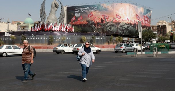 People walk past an anti-U.S. billboard at Enghelab Square, central Tehran, Iran, Aug. 9, 2026. (EPA Photo)