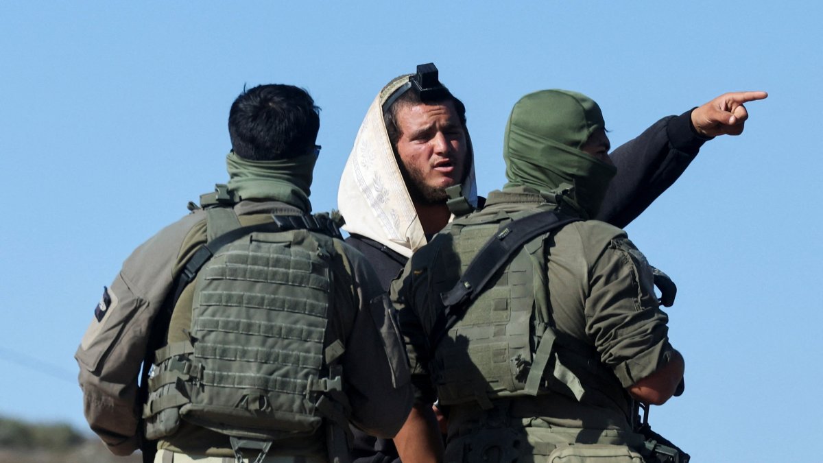 Israeli soldiers speak to an Israeli militant settler who entered Palestinian-American Louay Abu Rida's property in Qusra, the Israeli-occupied West Bank, Aug. 18, 2026. (Reuters Photo)