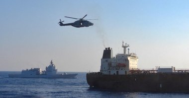 An Italian military helicopter and navy ship encircle the EU-sanctioned oil tanker Toa Payoh, in the foreground, which is described as part of Russia's "shadow fleet" by the EU, in international waters west of the Italian island of Pantelleria, Aug. 2, 2026. (Reuters Photo)