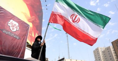 A woman flies Iran's national flag at the Valiasr Square in Tehran, Iran, Aug. 17, 2026. (EPA Photo)