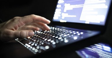 A person types with his fingers on an illuminated laptop keyboard, Berlin, Dec. 14, 2025. (AFP File Photo)