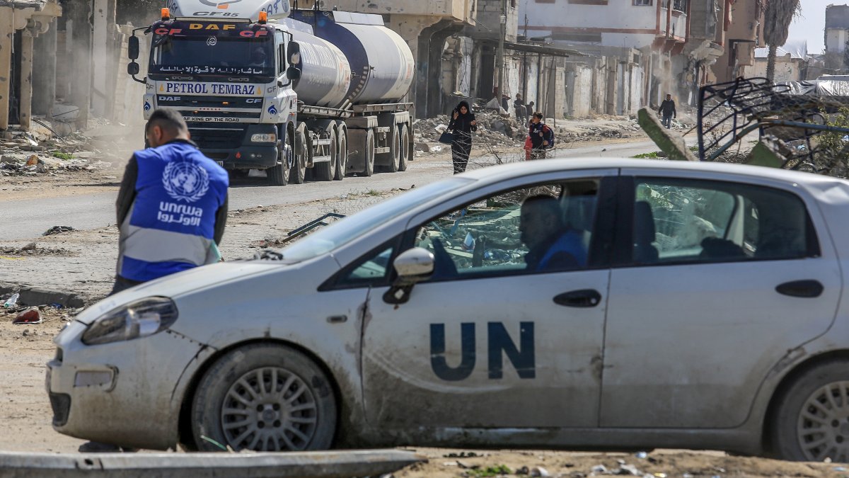 A UNRWA worker leans on a U.N. vehicle as trucks loaded with humanitarian aid cross into the Gaza Strip near Rafah, Gaza, Feb. 17, 2025. (Getty Images Photo)