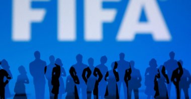 The FIFA logo and silhouettes of people are seen in this illustration, July 30, 2026. (Reuters Photo)