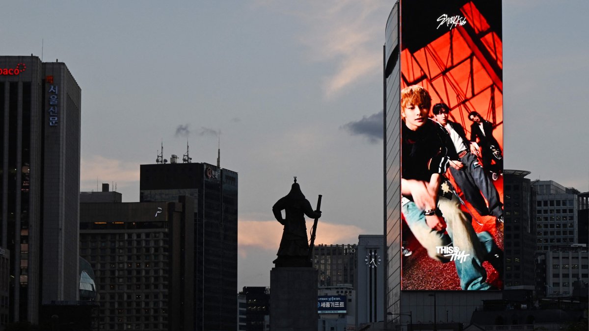 An advertisement for K-pop group Stray Kids displayed on a giant screen on the side of a building near the statue of Admiral Yi Sun-sin, Gwanghwamun district, Seoul, South Korea, Aug. 12, 2026. (AFP Photo)