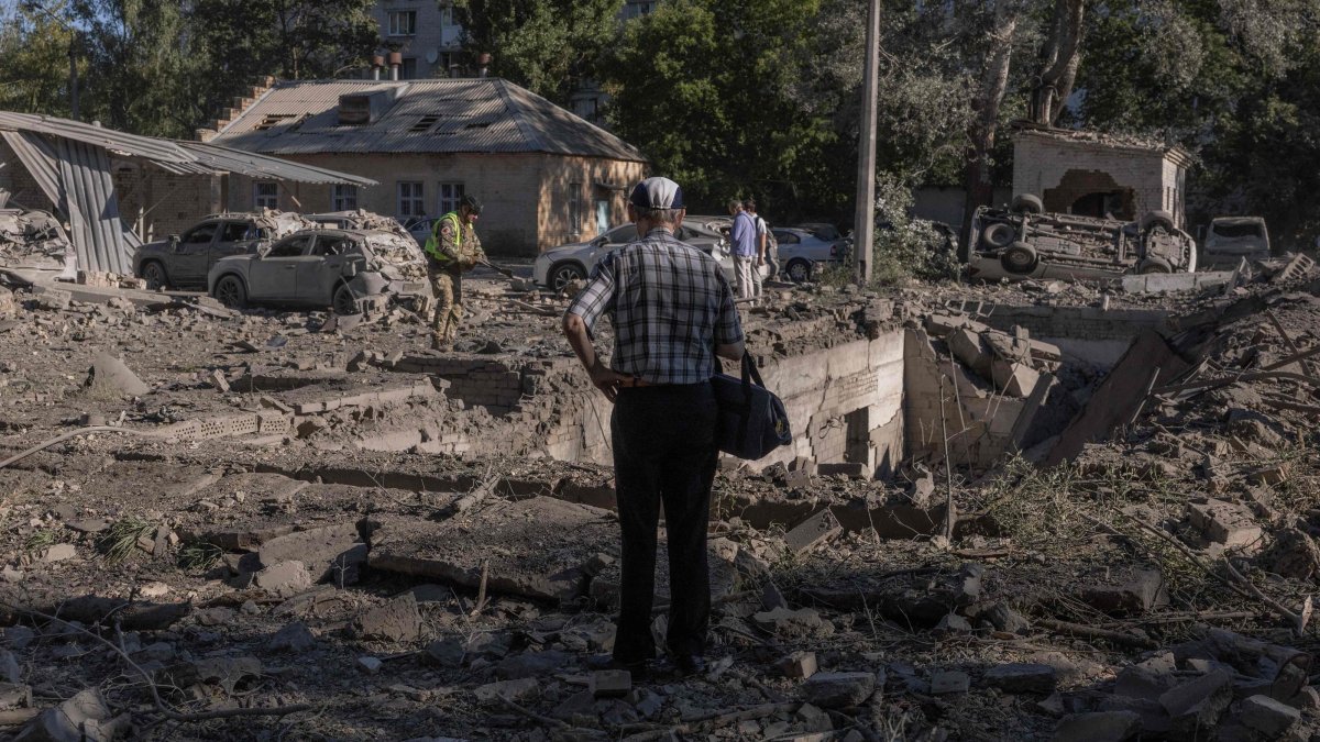 A person stands next to cars and buildings damaged in a Russian strike that a hospital in Kyiv, Ukraine, Aug. 20, 2026. (AFP Photo)