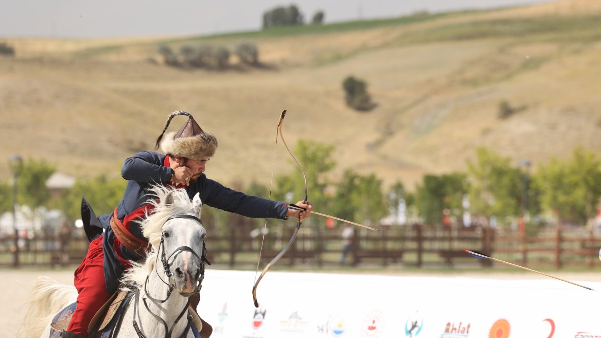 A competitor dressed in traditional clothing performs mounted archery on a galloping white horse. (Courtesy of Okçular Vakfı)