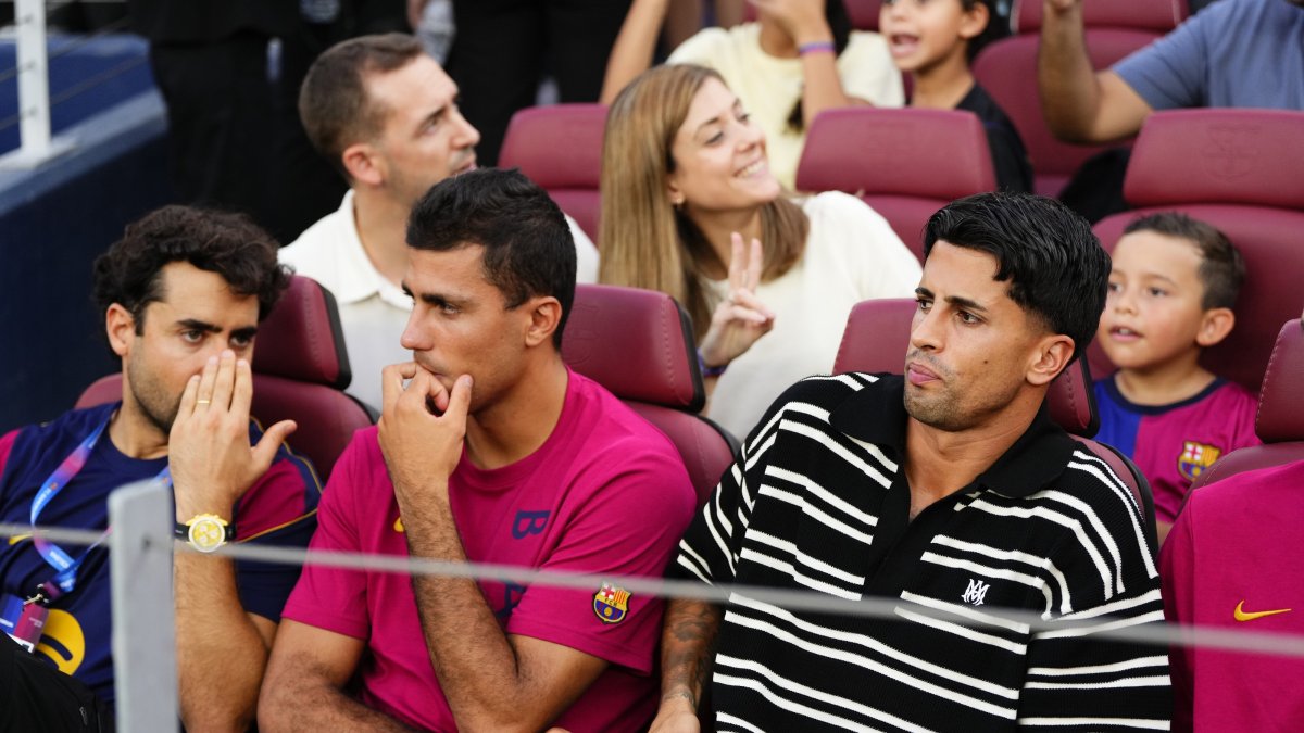 Barcelona's Rodri (C) and Joao Cancelo (R) watch from the stands during the Joan Gamper Trophy match against Al Ahly at the Camp Nou, Barcelona, Spain, Aug. 19, 2026. (AA Photo)
