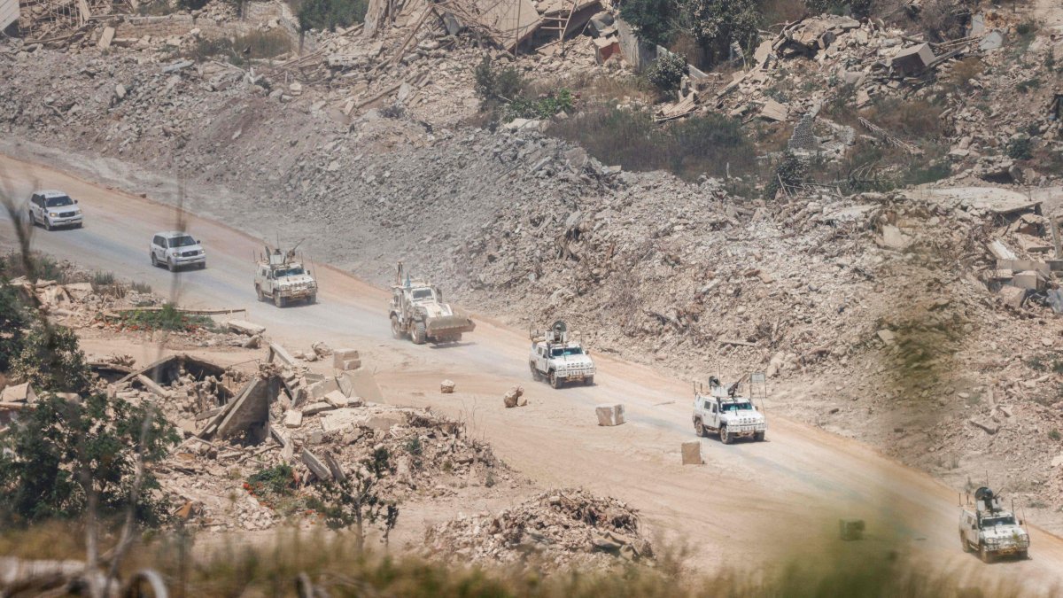 This picture, taken from a position in northern Israel, near the border with Lebanon, shows United Nations Interim Force in Lebanon (UNIFIL) armored vehicles driving past destroyed buildings in southern Lebanon, July 22, 2026. (AFP File Photo)