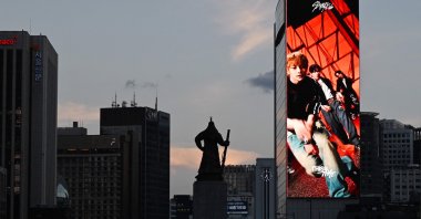 An advertisement for K-pop group Stray Kids displayed on a giant screen on the side of a building near the statue of Admiral Yi Sun-sin, Gwanghwamun district, Seoul, South Korea, Aug. 12, 2026. (AFP Photo)