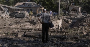 A person stands next to cars and buildings damaged in a Russian strike that a hospital in Kyiv, Ukraine, Aug. 20, 2026. (AFP Photo)