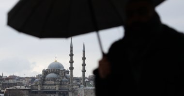 A view of the New Mosque as a person walks with an umbrella, Istanbul, Türkiye, Jan. 12, 2026. (Getty Images Photo)