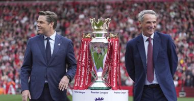 Premier League Chief Executive Officer Richard Masters (L) and former footballer Alan Hansen pose with the winner's trophy after the English Premier League match between Liverpool and Crystal Palace at Anfield Stadium, Liverpool, U.K., May 25, 2025. (AP Photo)