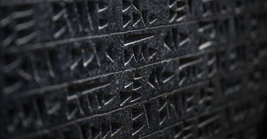A tablet unearthed with a surface displaying circles, dots, triangles and square or rectangular motifs formed using scratching and pressing techniques, July 22, 2026. (AFP Photo)