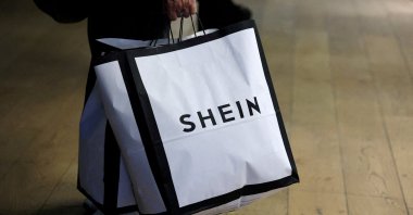 A customer holds shopping bags with a Shein logo in the first physical space of online fast-fashion retailer Shein on the day of its opening inside the Le BHV Marais department store, the Bazar de l'Hotel de Ville, in Paris, France, Nov. 5, 2025. (Reuters Photo)