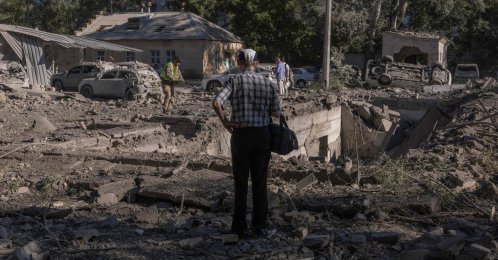 A person stands next to cars and buildings damaged in a Russian strike that a hospital in Kyiv, Ukraine, Aug. 20, 2026. (AFP Photo)