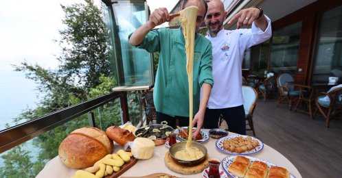 A chef serves kuymak alongside kaygana, collard-green rolls, cornbread, Trabzon butter and other traditional Black Sea dishes, Trabzon, Türkiye, Aug. 18, 2026. (AA Photo)